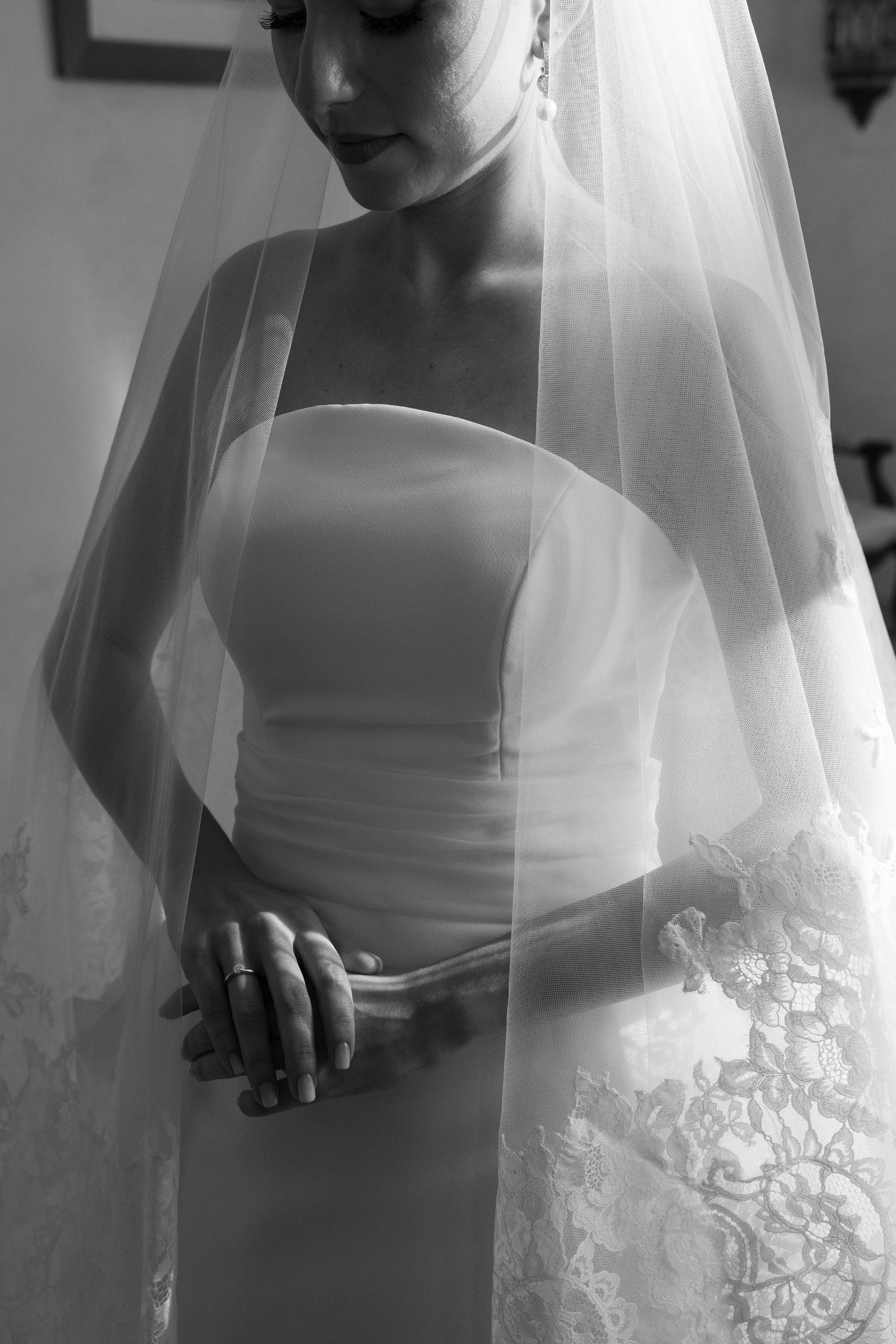 Detalle en blanco y negro del encaje del velo sobre el vestido